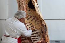 butcher preparing a grass-fed cow, aged beef from arrowhead beef